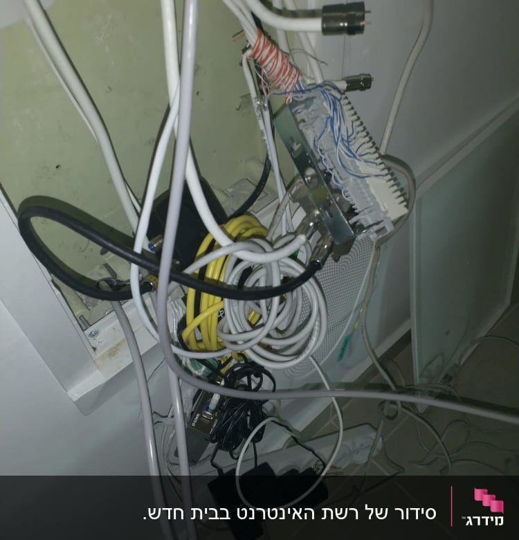 חוטי רשת מחוברים ללוח תקשורת בקיר